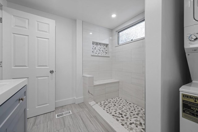 bathroom with vanity and a tile shower