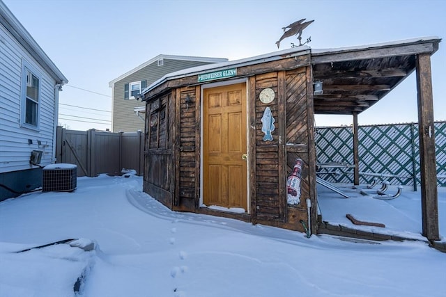 snow covered structure featuring cooling unit