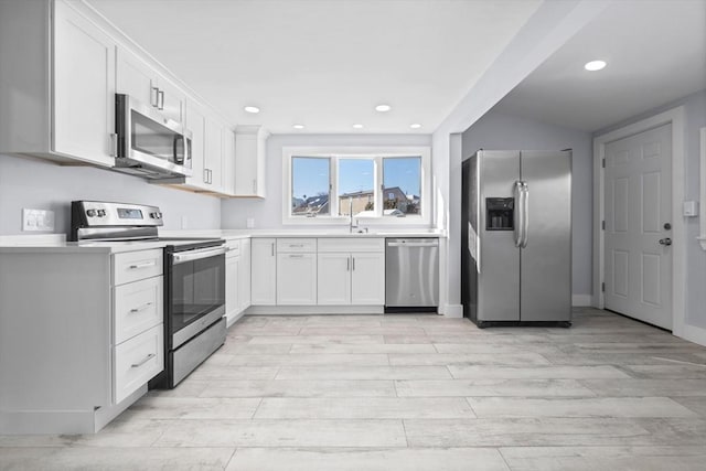 kitchen featuring appliances with stainless steel finishes, sink, and white cabinets