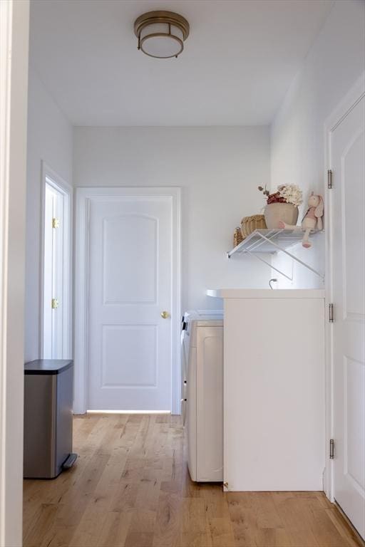laundry room with light wood-style flooring, laundry area, and washing machine and dryer