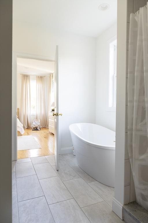 full bathroom featuring a soaking tub and tile patterned flooring