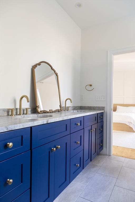 ensuite bathroom featuring tile patterned floors, double vanity, ensuite bathroom, and a sink