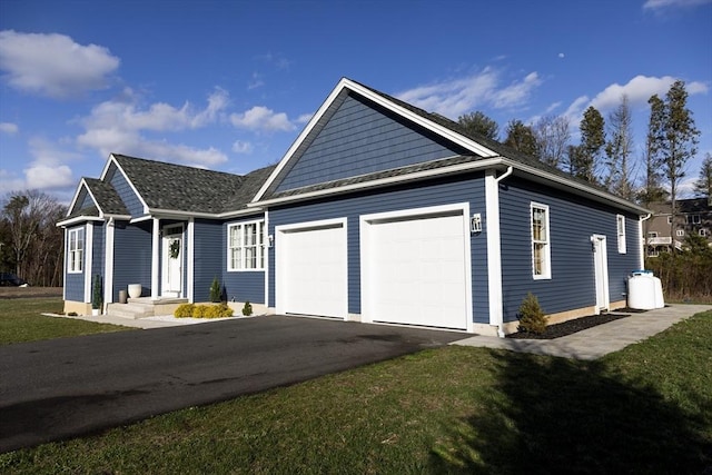 single story home featuring an attached garage, aphalt driveway, and a front lawn
