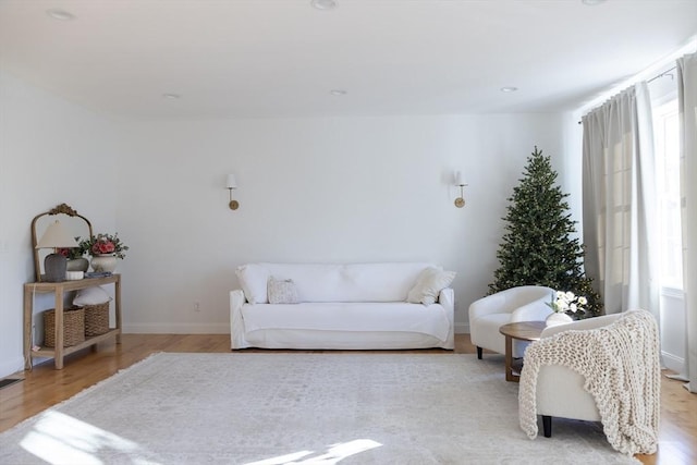 living area featuring light wood-type flooring, baseboards, and visible vents