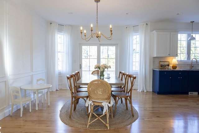 dining area with an inviting chandelier and light wood-style floors