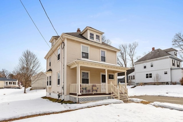 american foursquare style home with covered porch and a chimney