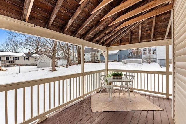 snow covered deck featuring a residential view