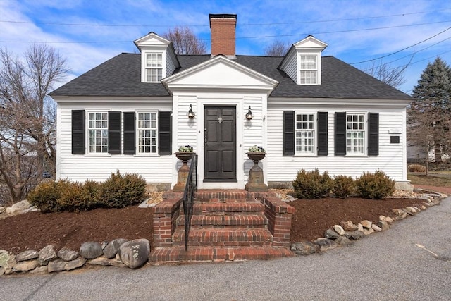 cape cod-style house with a chimney and a shingled roof