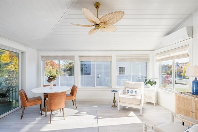 sunroom / solarium featuring vaulted ceiling, a wall mounted AC, and a wealth of natural light