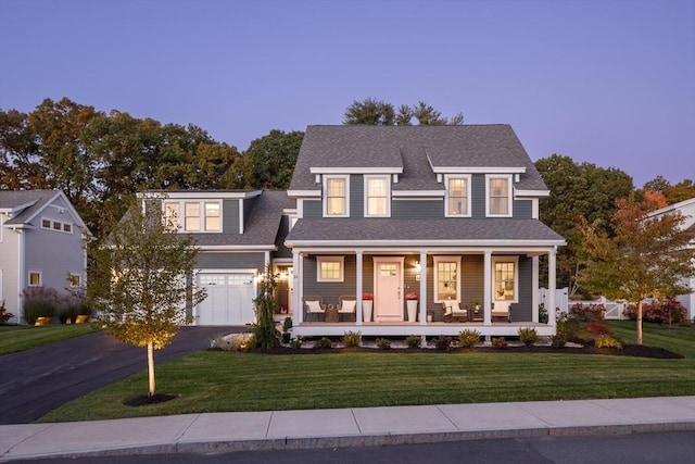 shingle-style home featuring aphalt driveway, a porch, a shingled roof, and a front yard