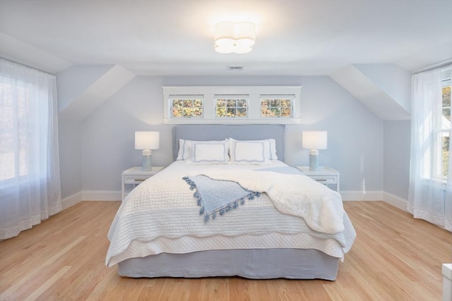 bedroom featuring light wood-style floors, visible vents, and baseboards