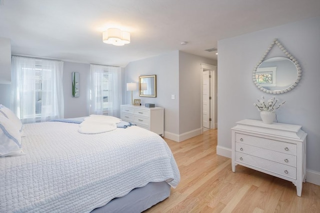 bedroom featuring baseboards and light wood-style floors