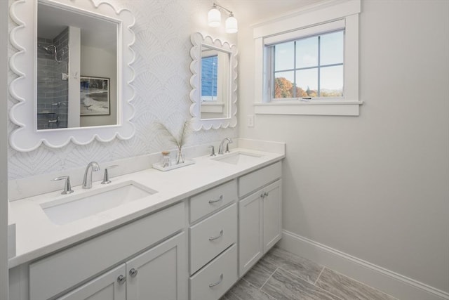 bathroom with baseboards, a sink, and wallpapered walls