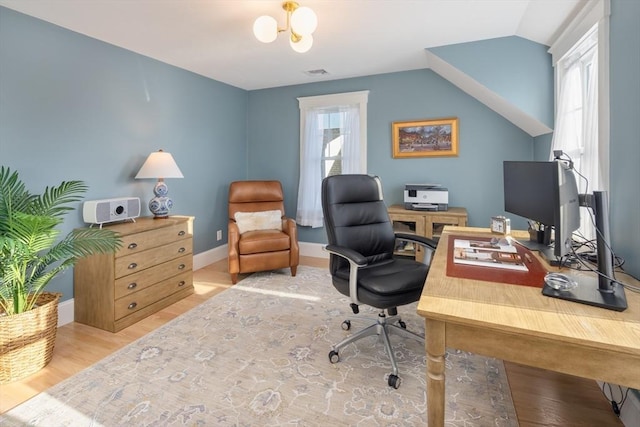 home office with visible vents, vaulted ceiling, baseboards, and wood finished floors