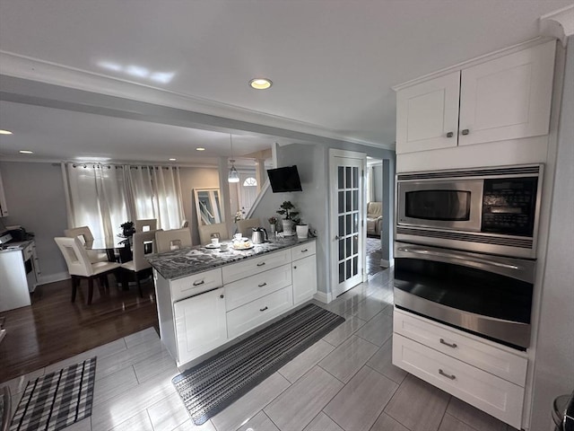 28 Roberts St, Malden, MA 02148 - kitchen with appliances with stainless steel finishes, white cabinets, stone counters, a peninsula, and baseboards