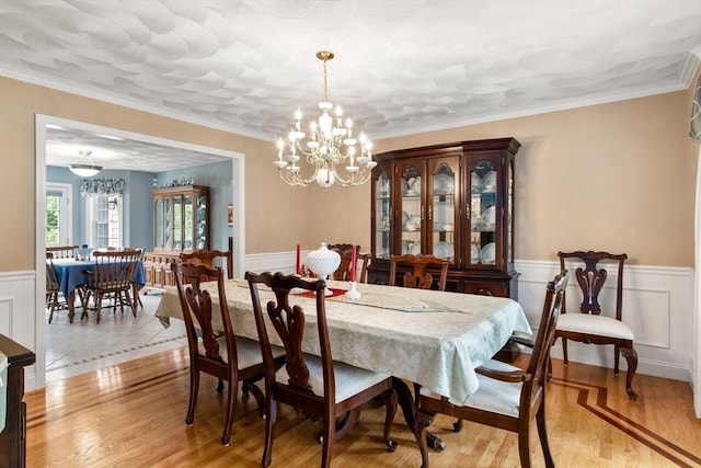 75 Birchwood Rd, Tewksbury, MA 01876 - dining space featuring a chandelier, a wainscoted wall, light wood-style flooring, and ornamental molding