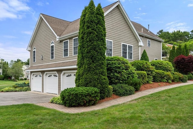 75 Birchwood Rd, Tewksbury, MA 01876 - view of home's exterior with a garage, roof with shingles, asphalt driveway, and a yard