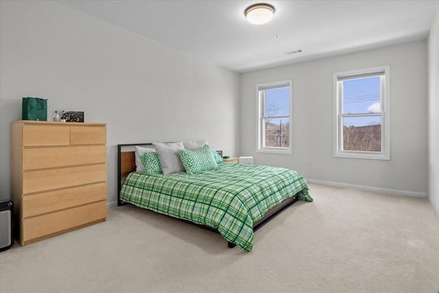 carpeted bedroom with visible vents and baseboards