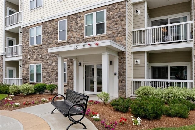 exterior space featuring french doors and stone siding