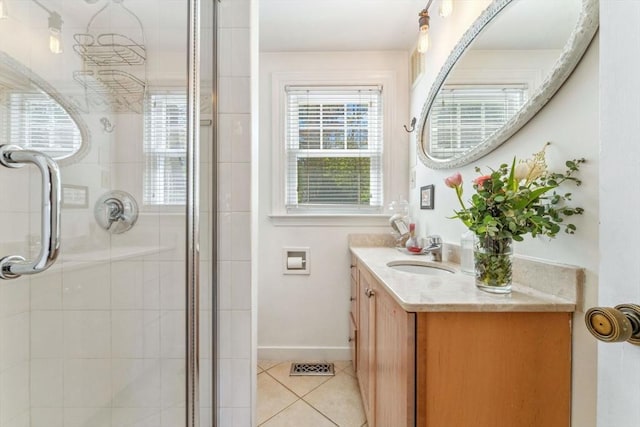 full bath with tile patterned flooring, vanity, baseboards, a shower stall, and visible vents
