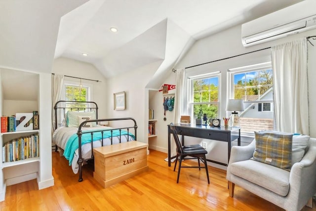 bedroom featuring light wood-style floors, a wall mounted air conditioner, baseboards, and lofted ceiling