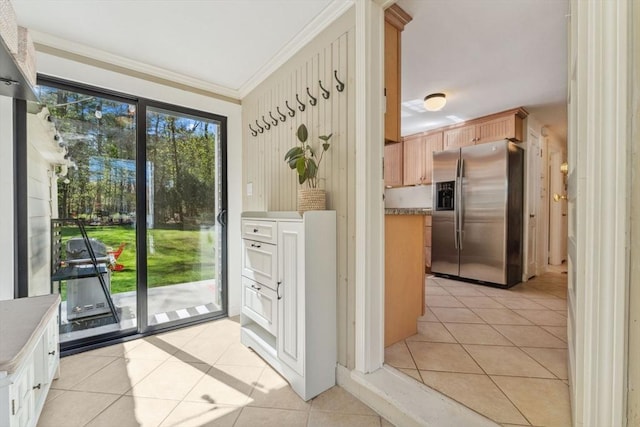 doorway featuring light tile patterned flooring and ornamental molding