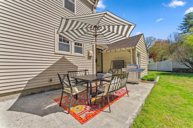 view of patio / terrace featuring fence, outdoor dining area, and a grill