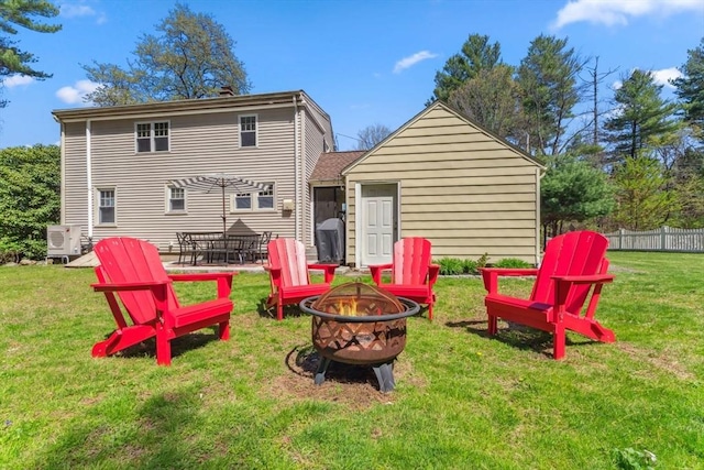 back of house featuring a yard, ac unit, fence, and a fire pit