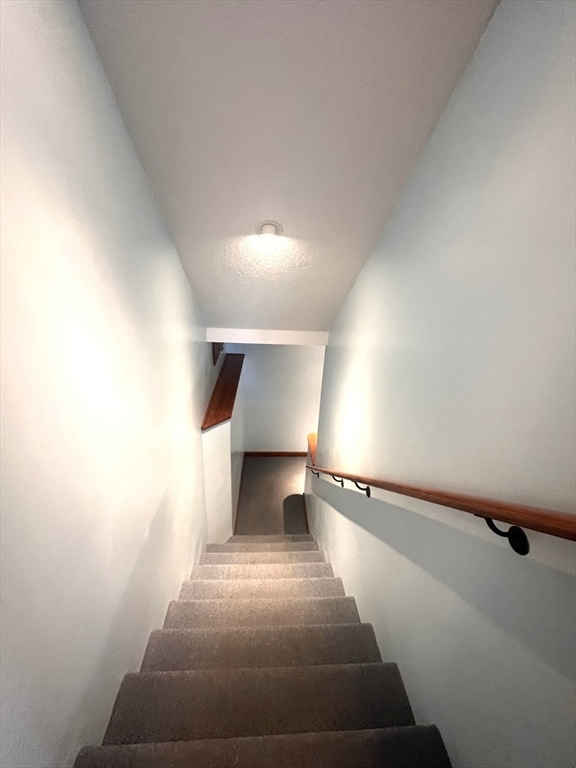 staircase featuring lofted ceiling