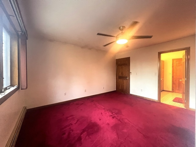 carpeted spare room featuring a baseboard radiator and ceiling fan