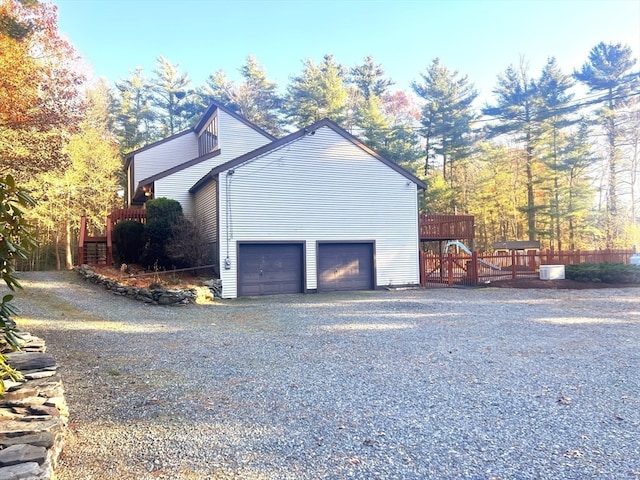 view of side of home featuring a garage and a wooden deck