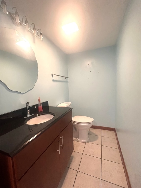 bathroom with toilet, vanity, and tile patterned floors