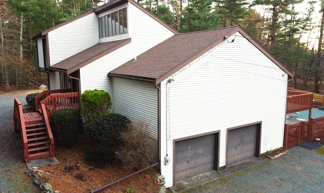 view of side of property featuring a garage and a deck