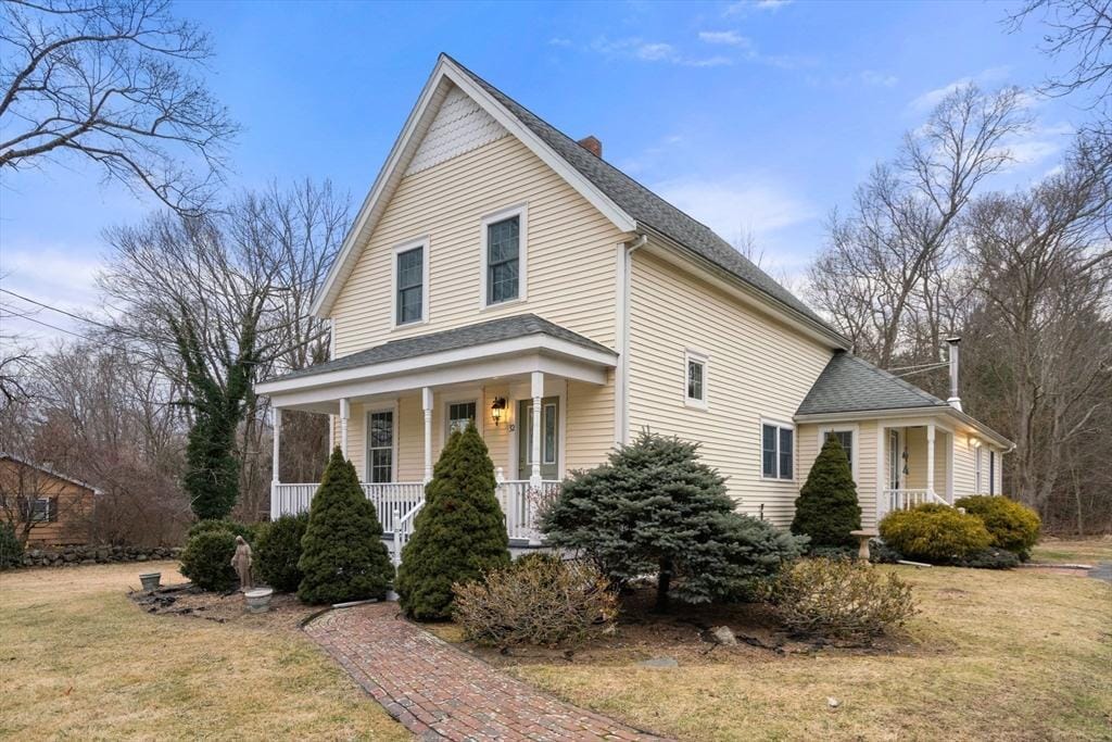 view of front of house with covered porch and a front lawn