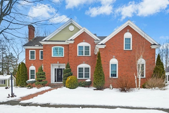 colonial house with brick siding and a chimney