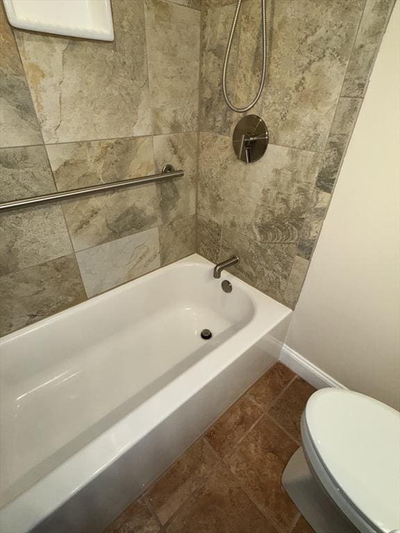 bathroom featuring tile patterned floors, toilet, and tiled shower / bath