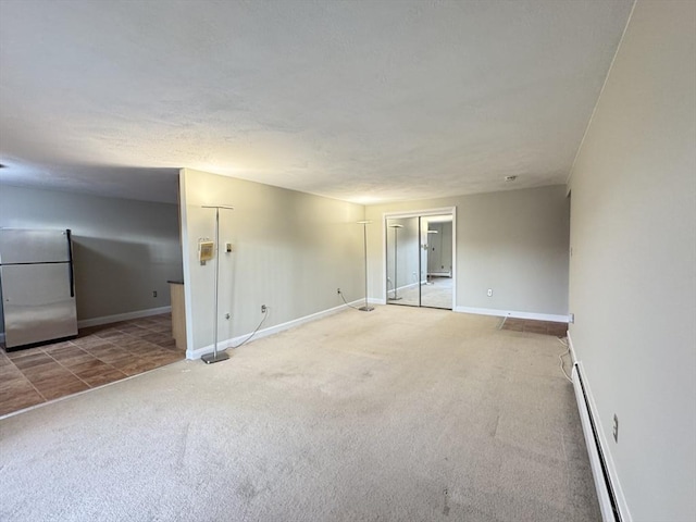 carpeted empty room with a baseboard radiator