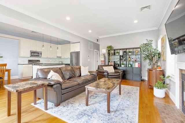474 E 3rd Unit 2, Boston, MA 02127 - living area with light wood finished floors, ornamental molding, recessed lighting, a fireplace with flush hearth, and baseboards