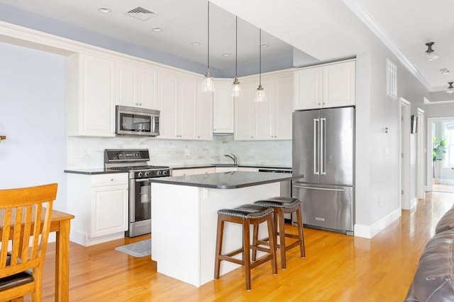 474 E 3rd Unit 2, Boston, MA 02127 - kitchen featuring stainless steel appliances, dark countertops, ornamental molding, light wood finished floors, and white cabinetry