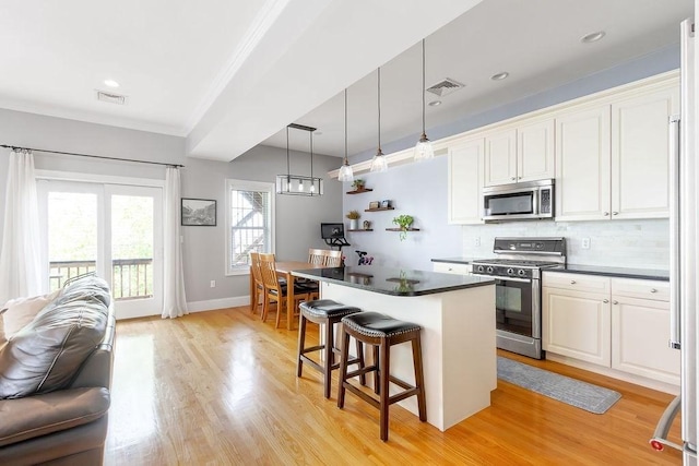 474 E 3rd Unit 2, Boston, MA 02127 - kitchen featuring stainless steel appliances, a kitchen bar, dark countertops, a center island, and backsplash