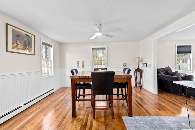 dining area featuring a baseboard radiator, ceiling fan, and light hardwood / wood-style floors