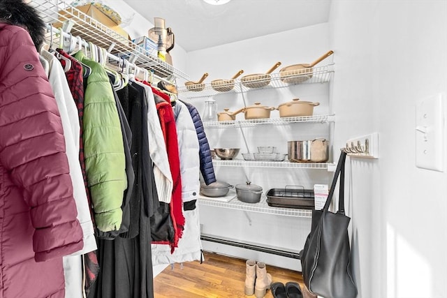 walk in closet featuring hardwood / wood-style flooring and a baseboard radiator