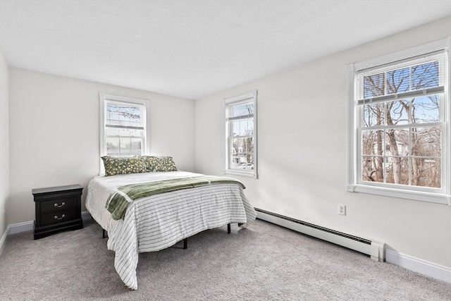 carpeted bedroom with baseboard heating and multiple windows