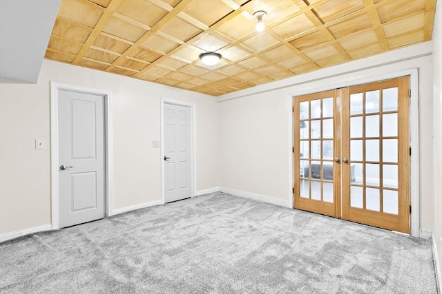 carpeted spare room with french doors and coffered ceiling