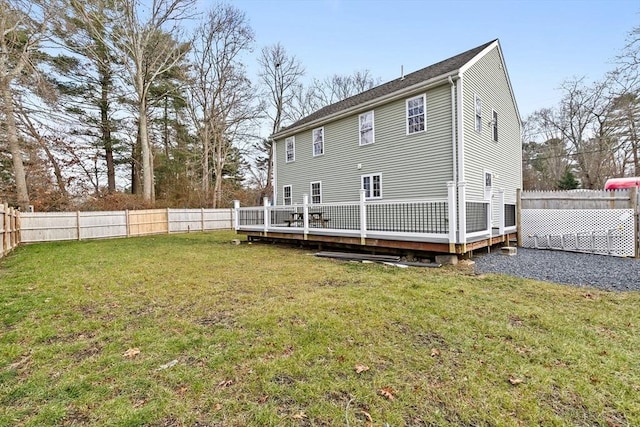 rear view of property featuring a deck and a lawn