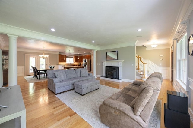 2 Powers Rd, Mendon, MA 01756 - living room with a decorative wall, stairway, ornamental molding, light wood-style flooring, and a wainscoted wall
