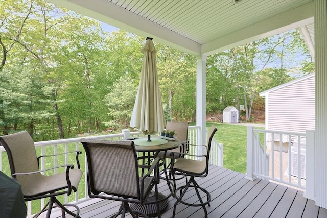 2 Powers Rd, Mendon, MA 01756 - deck featuring a storage unit, an outbuilding, a yard, outdoor dining area, and view of wooded area