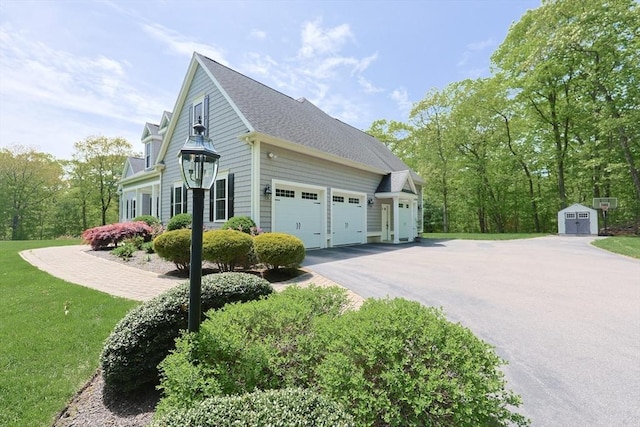 2 Powers Rd, Mendon, MA 01756 - view of property exterior with a storage unit, a garage, an outbuilding, driveway, and a lawn