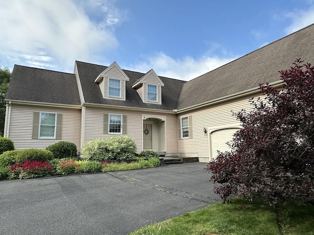 view of front of home with a garage, driveway, and a shingled roof