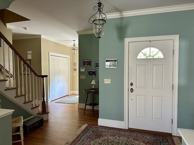 foyer featuring stairs, crown molding, baseboards, and dark wood-type flooring